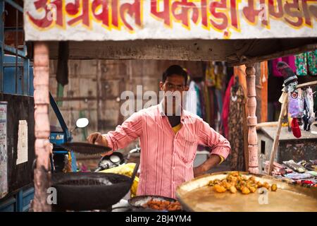 Ein Street-Food-Anbieter verkauft frittierte Snacks auf der Straße in der Stadt Jaipur in Indien. Stockfoto