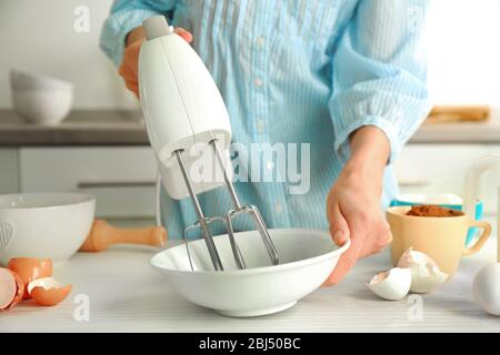 Frau mischt Eier in einer Schüssel Stockfoto