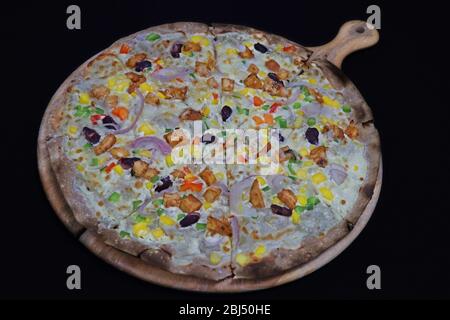 Dünne verkrustete italienische Mischung vegetabls Pizza in einem Holzbrett Stockfoto