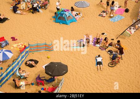 Sonnenanbeter an einem Kent Strand in England. Stockfoto