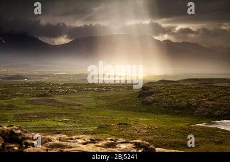 Sonnenlicht strömt durch stürmische Wolken in Island. Stockfoto