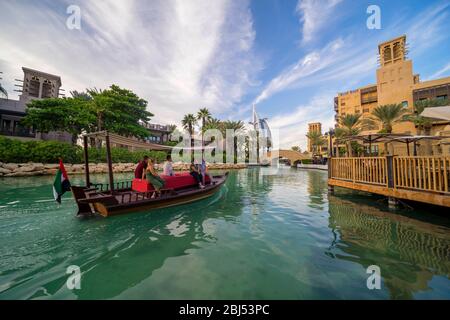 Ein Abra Boot gleitet durch das klare blaue Wasser des Souk Madinat Jumeirah. Stockfoto