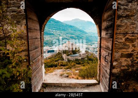 Sion, Schweiz: Mittelalterliche Basilika Valere durch die Haupttore des Schlosses Tourbillon im Kanton Wallis gesehen Stockfoto