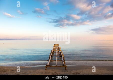 Blick auf den Sonnenaufgang auf einen Holzsteg am Ipsos Strand, Korfu, Griechenland Stockfoto