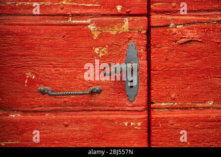 Vintage rote Holztür mit altem Eisengriff Stockfoto