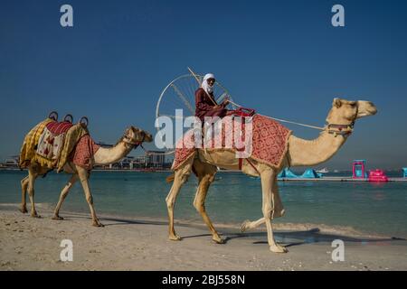 Ein Beduinenmann lächelt, als er vor Ain Dubai vorbeifährt, dem größten Riesenrad der Welt am Jumeirah Beach in Dubai. Stockfoto