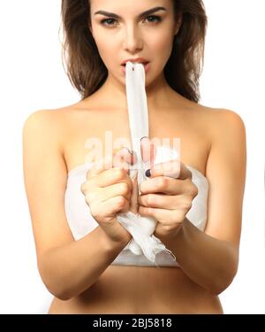 Junge schöne Frau zerreißt Gaze mit ihren Zähnen, isoliert auf weiß Stockfoto