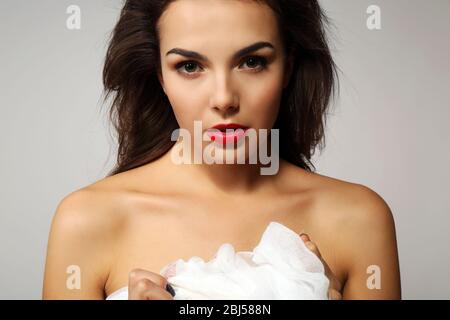 Junge schöne Frau, hält Gaze, auf grauem Hintergrund Stockfoto