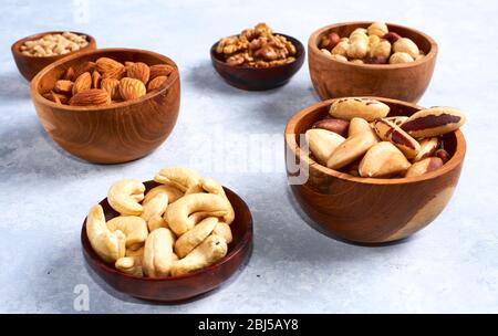 Mandeln, Walnüsse und Haselnüsse in Holzschalen auf hölzernen Hintergrund Stockfoto