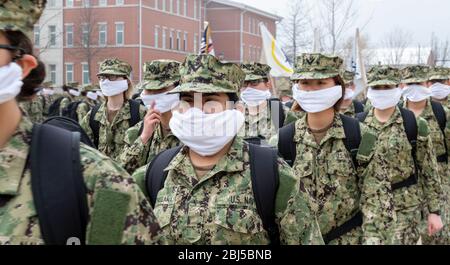 Rekruten der US-Marine tragen Gesichtsmasken, um die Ausbreitung des COVID-19, Coronavirus, zu verhindern, während sie in Formation beim Recruit Training Command am 15. April 2020 in Great Lakes, Illinois marschieren. Stockfoto