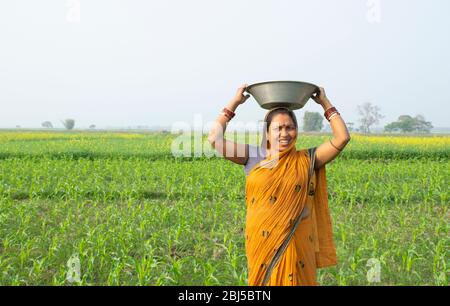 indische Frau Bauer mit Korb auf dem Kopf Stockfoto