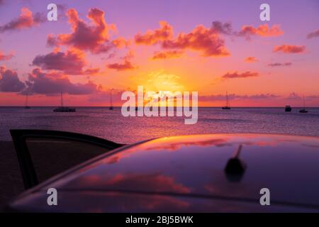 Tropische Sonnenuntergänge auf dem Autodach mit geöffneter Tür Stockfoto