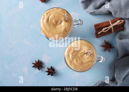 Iced Dalgona Kaffee in zwei Gläsern mit Gewürzen auf hellblauem Beton Hintergrund. Koreanischer cremiger Schlagkaffee Trend, Copy Space, Horizontal Format Stockfoto