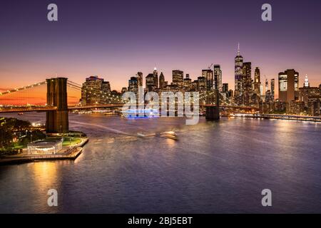 Brooklyn Bridge über den East River und die Skyline von Manhattan bei Nacht in New York USA Stockfoto