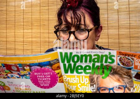 Ältere Frau beim Lesen des Wochenmagazins der Frau Stockfoto