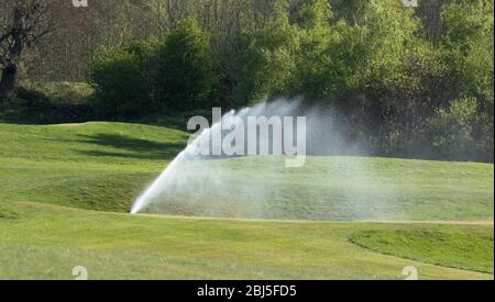 Ein Bewässerungssystem, das einen Golfplatz bewässert. Stockfoto