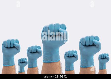 Fäuste Hände in medizinischen blauen Latex Schutzhandschuhe als Zeichen der Resistenz gegen Pandemie - auf weißem Hintergrund Krankheit Zeichen zu stoppen Stockfoto