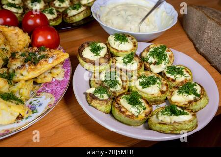 Hausgemachte Blumenkohl in Teig und Zucchini mit Sauce Tartar und Tomaten Stockfoto