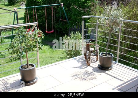 Eine Terrasse mit Edelstahlgeländer und beigefarbenen Bodenfliesen eine Terrasse mit Edelstahlgeländer und beigen Bodenplatten Stockfoto