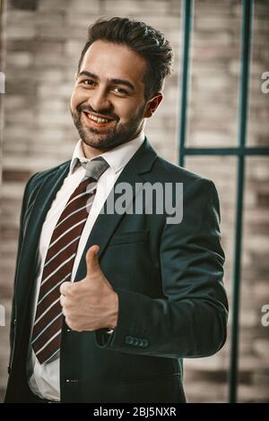 Handsome Man In Suite Zeigt Daumen Nach Oben Im Büro Stockfoto