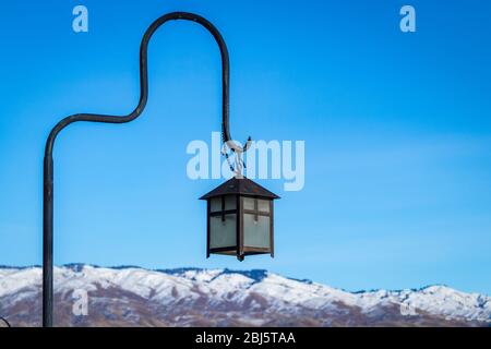 Hängelampe steht gegen schneebedeckten Berg und blauen Himmel in landschaftlich schönen Winter Einstellung. Stockfoto