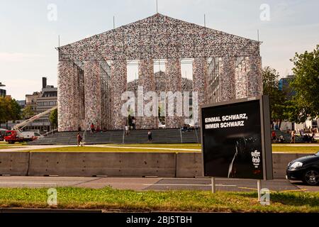 Werbung für ein schwarzes Bier vor Parthen of Books auf der Documenta 2017 in Kassel. Die argentinische Künstlerin Marta Minujin hat unzählige Bücher über einen Parthenon auf einem Gerüst aufgestellt Stockfoto