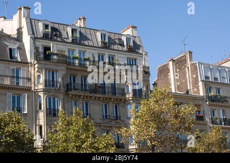 Typisches Design der Pariser Architektur. Die Fassade eines französischen Gebäudes im modernen Stil mit Fenstern und französischen Balkonen in Paris, Frankreich. Stockfoto