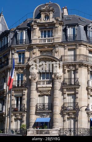 Typisches Design der Pariser Architektur. Die Fassade eines französischen Gebäudes im modernen Stil mit Fenstern und französischen Balkonen in Paris, Frankreich. Stockfoto