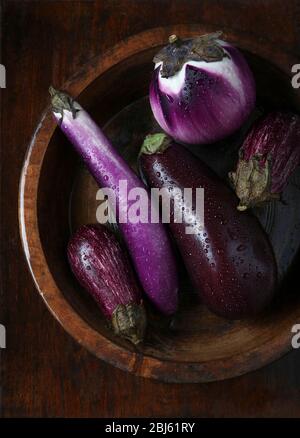 Auberginen in Holzschüssel nass mit Tröpfchen Stockfoto