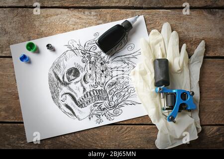 Tattoo Maschine, Skizze und Tattoo Zubehör, auf alten Holztisch Stockfoto