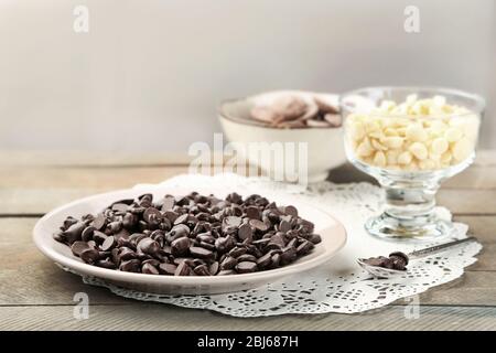 Schokoladenstückchen auf Holzhintergrund Stockfoto