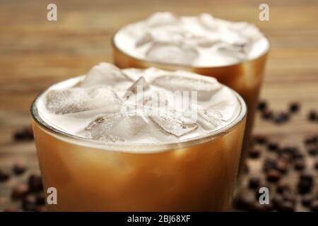 Zwei Tassen Eiskaffee mit Kaffeebohnen auf Holztisch Stockfoto