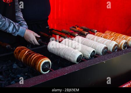 Kurtos kalacs oder Schornsteinkuchen, Kochen auf Holzkohlegrill, Street Food traditionelle ungarische, während des Food Festival. Kurtos Kalacs traditiona Stockfoto