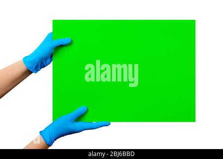 Leere grüne Karte in Arzthand in blauen Handschuhen mit Kopierraum, isoliert auf weißem Hintergrund. Beschneidungspfad enthalten. Stockfoto