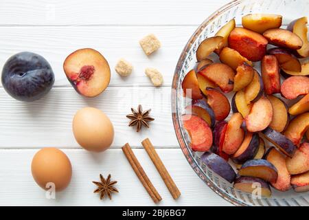Pflaume hausgemachte Kuchen Zutaten auf weißem Holztisch, Draufsicht. Stockfoto