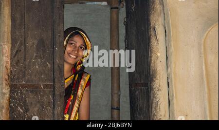 Glückliche Frau, die vor der Tür des Hauses im Dorf, Indien steht Stockfoto