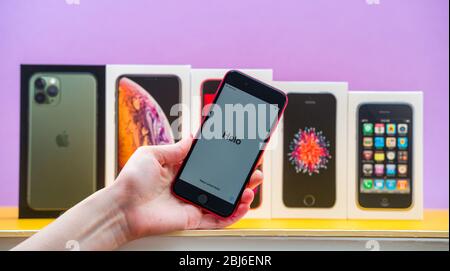 Paris, Frankreich - Apr 26, 2020: Frau Hand hält neueste iPhone SE 2020 Telefon mit mehreren Paketen Kartons von Apple Computern iPhone smartphpone iPhone 3gs, SE 2016, XS und 11 Pro Stockfoto