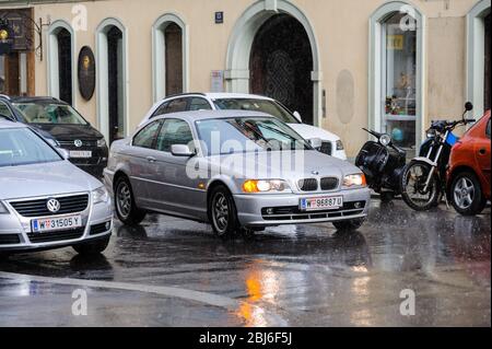 Wien, Österreich - 5. Jul 2011: Seitenansicht des neuen BMW Coupé Autos, das auf nassem Asphalt fährt Regentag im Zentrum von Wien Stockfoto