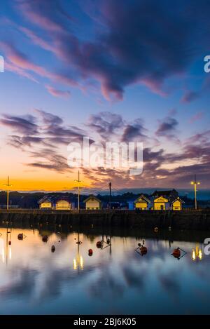 West Bay, Dorset, Großbritannien. April 2020. Wetter in Großbritannien. Kurz nach Sonnenuntergang beginnen sich die Wolken über dem Hafen im Seebad West Bay in Dorset nach einem Tag mit leichtem Regen und bewölktem Himmel zu klären. Bild: Graham Hunt/Alamy Live News Stockfoto