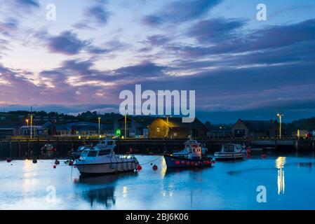 West Bay, Dorset, Großbritannien. April 2020. Wetter in Großbritannien. Kurz nach Sonnenuntergang beginnen sich die Wolken über dem Hafen im Seebad West Bay in Dorset nach einem Tag mit leichtem Regen und bewölktem Himmel zu klären. Bild: Graham Hunt/Alamy Live News Stockfoto