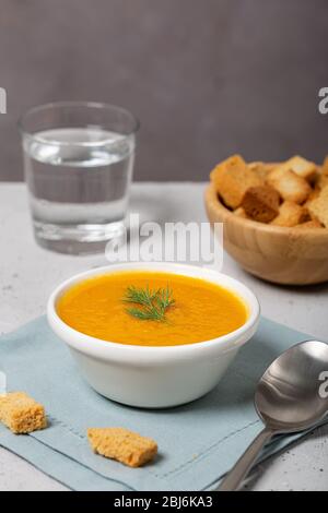 Kürbis- und Karottensuppe mit frischem Dill auf dem Tisch Stockfoto
