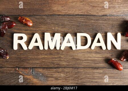 Bild des Wortes RAMADAN und Datteln Frucht auf Holzhintergrund, Nahaufnahme Stockfoto