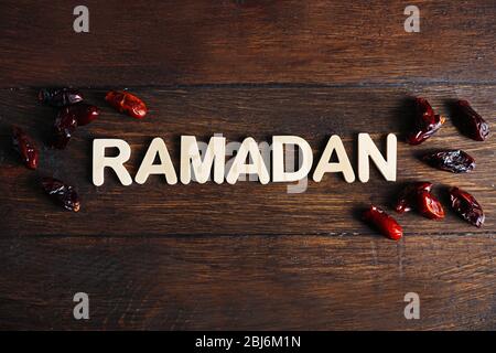 Bild des Wortes RAMADAN und Datteln Frucht auf Holzhintergrund, Nahaufnahme Stockfoto