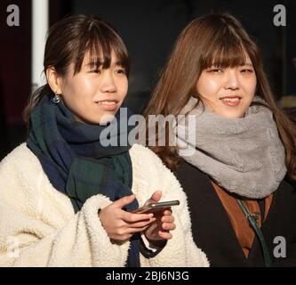 Zwei junge japanische Frauen, die im Oneo Park in Tokio, Japan, spazieren gehen Stockfoto