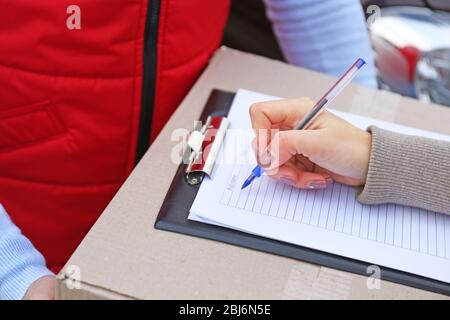 Weibliche Hand Signing Lieferform auf der Box, Nahaufnahme Stockfoto