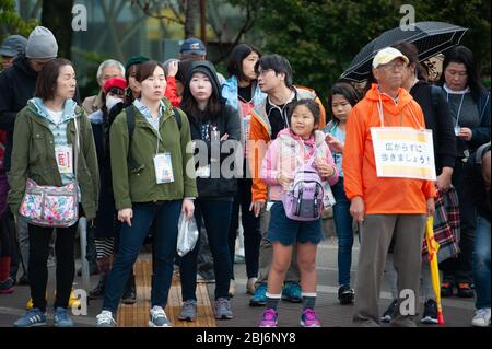 Gruppe von Menschen, die geduldig auf der Straße im Harajuku-Viertel in Tokio, Japan stehen. Stockfoto