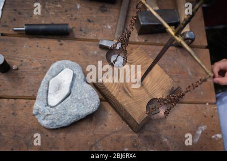 Manuelle Münzprägung. Münzprägung im Amboss. Arbeitsplatz. Waage mit Münze. Stockfoto