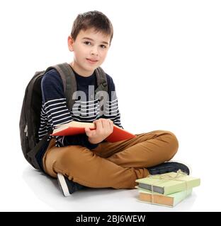 Niedlicher kleiner Junge mit grauen Rucksack Bücher lesen, isoliert auf weiß Stockfoto