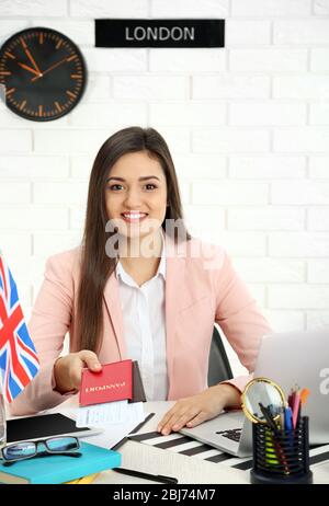 Junge Frau, die Pässe mit Tickets im Büro des Reiseunternehmens vorzeigt Stockfoto