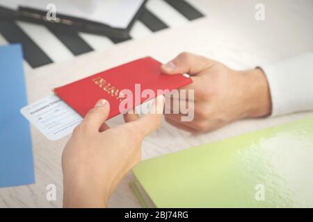 Reisebüro, das dem Kunden im Büro des Reiseunternehmens Reisepass und Ticket ausgibt Stockfoto